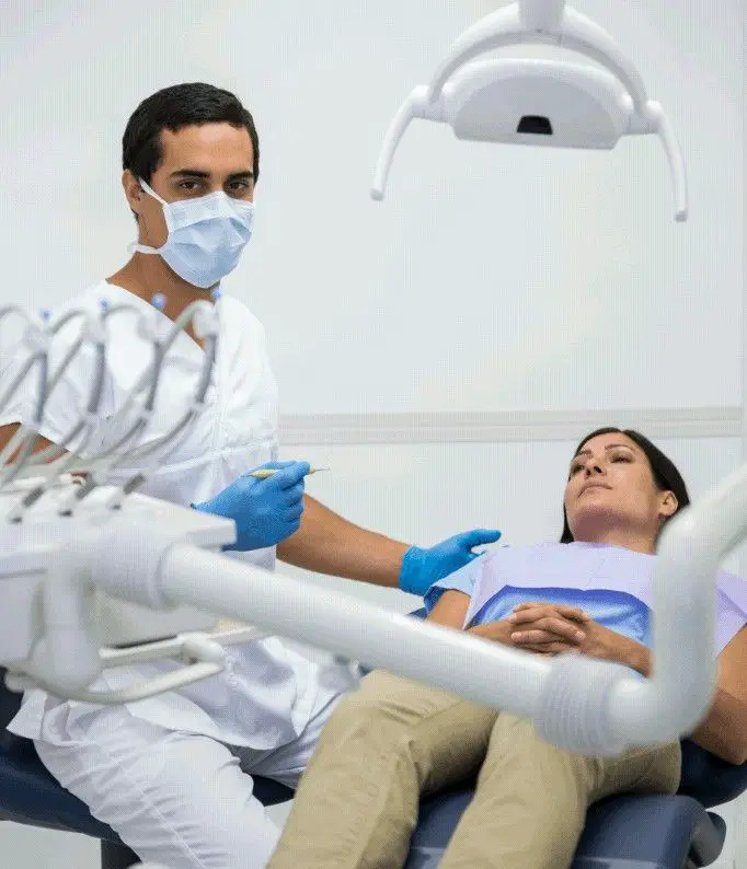 Realización de tartrectomía dental en una mujer en un sillón dental