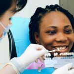 Elección del color en una joven mujer para la colocación de carillas dentales