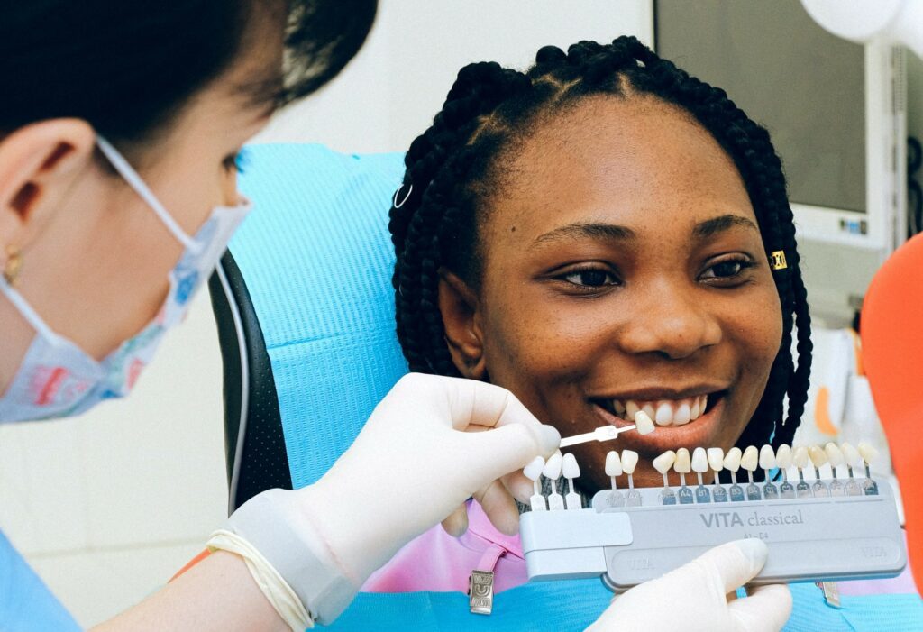 Elección del color en una joven mujer para la colocación de carillas dentales