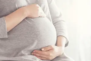 Mujer embarazada, sentada tocando su vientre
