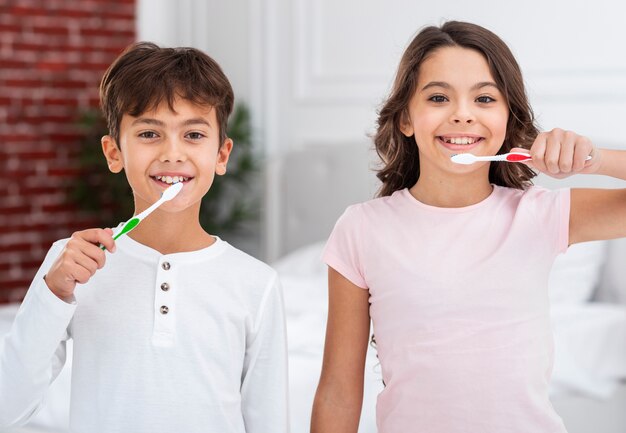 Niño y niña realizando cepillado dental